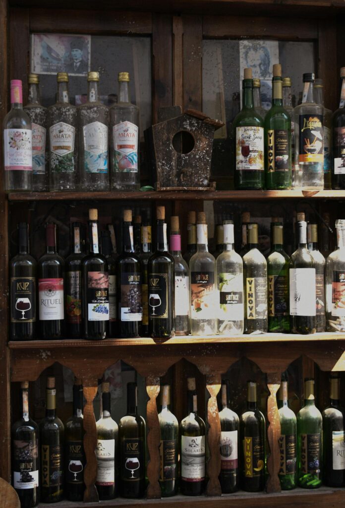 A variety of wine bottles displayed on rustic wooden shelves in Şirince, İzmir.
